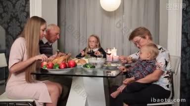 快乐的家庭与祖父母和孩子在餐桌上吃传统的感恩节食物多代家庭庆祝感恩节晚餐